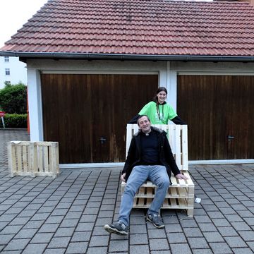 Pfarrer Lukes sitzt auf dem ersten Möbelstück...