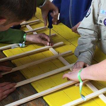 Mehrere Personen schrauben Holzlatten zusammen.